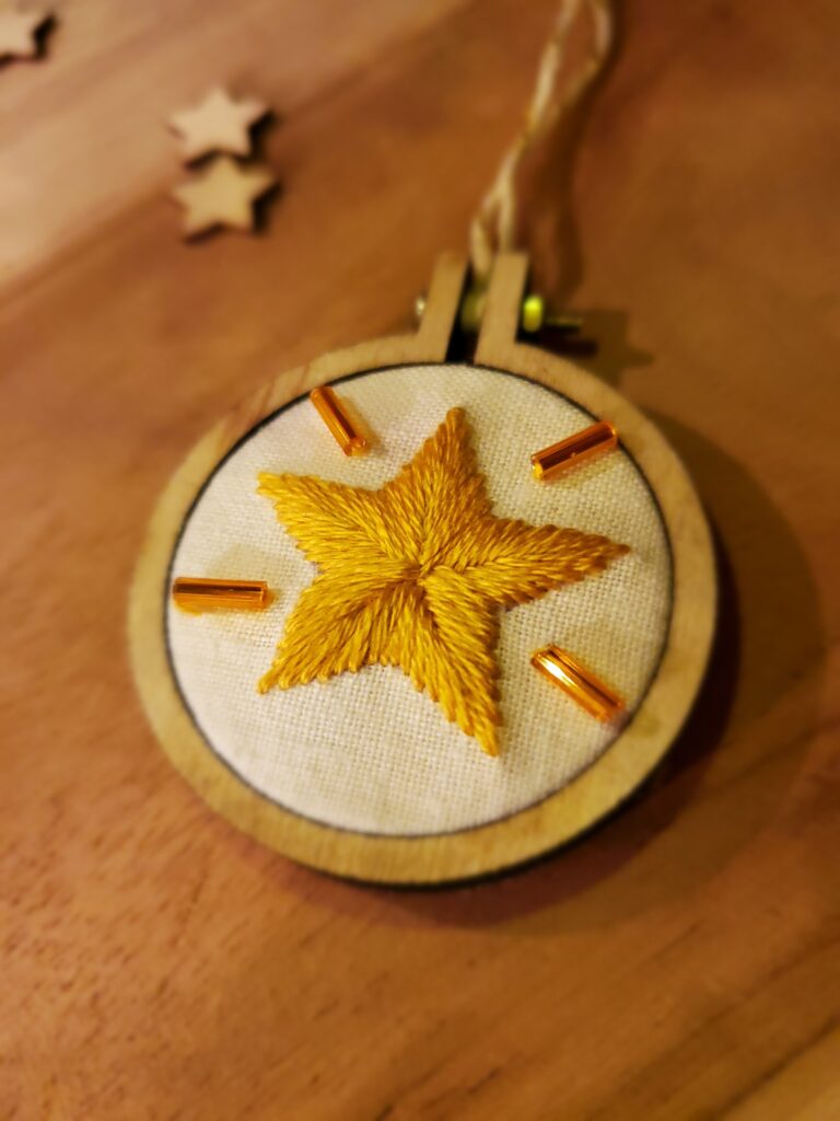 Mini-boule / médaillon brodé à la main représentant une étoile dorée entourée de perles dorées et brillantes